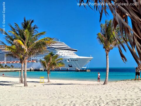 Praia paradisíaca no Caribe com areia branca, mar azul-turquesa, coqueiros e um navio de cruzeiro MSC ao fundo