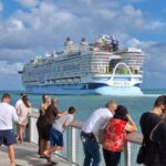 Pessoas observam o Icon of the Seas em Nassau — um dos maiores navios de cruzeiro do mundo, com 248.663 toneladas brutas