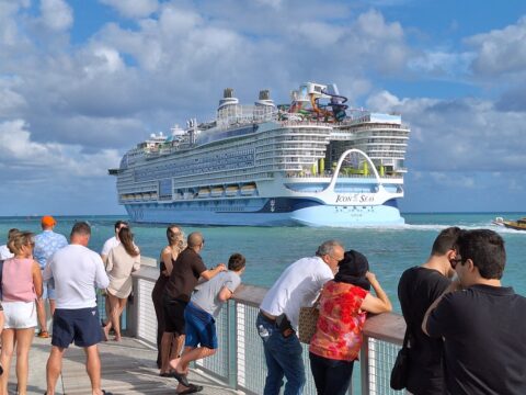 Pessoas observam o Icon of the Seas em Nassau — um dos maiores navios de cruzeiro do mundo, com 248.663 toneladas brutas