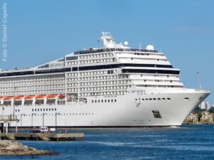 Perfil exterior do MSC Musica navegando, exibindo a estrutura dos conveses e varandas de passageiros