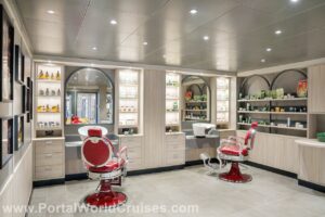 Interior da nova barbearia do MSC Aurea Spa, com cadeiras clássicas vermelhas, lavatórios e prateleiras iluminadas em madeira clara, parte da reforma do MSC Musica